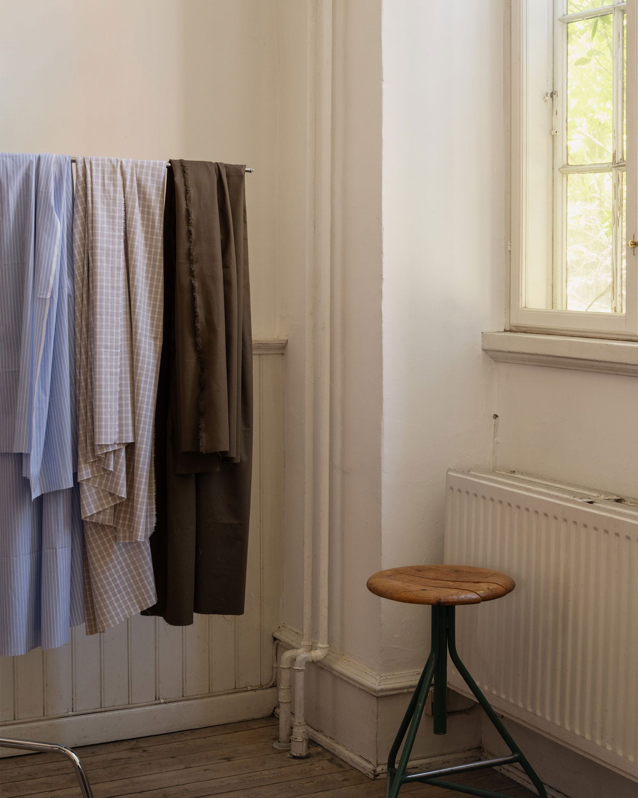 Image of deadstock fabrics for sewing home made clothes hanging on a rack 